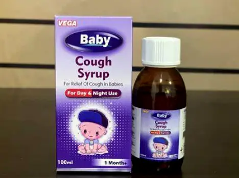 A baby in mid-cough with droplets visible in front of the mouth