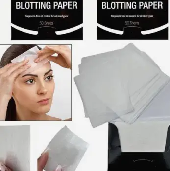 Person pressing a blotting paper against the shiny forehead to absorb surface oil.