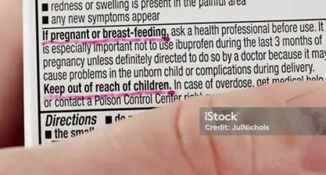 A parent giving liquid medicine to a child using a measuring spoon while a pregnant woman checks the Drug Facts label on a medicine bottle