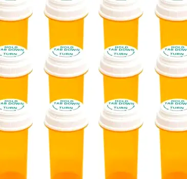 Child-resistant medicine bottles stored securely on a high shelf inside a closed cabinet.