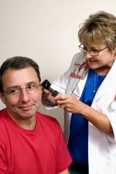 Clinician using an otoscope to inspect an ear canal and eardrum