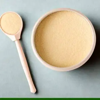 Collagen peptide powder being stirred into a glass of water