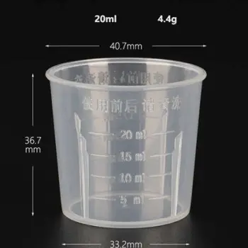 Person measuring medication with a clear dosing cup showing milliliter markings