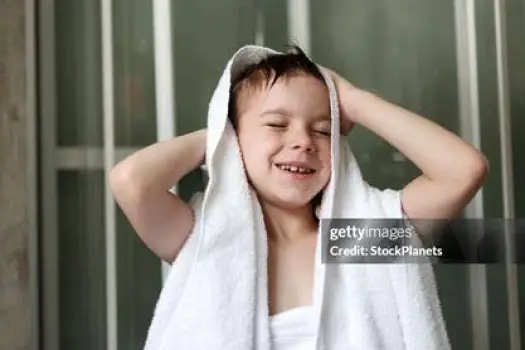 A person thoroughly drying their feet with a towel after bathing, keeping the skin between the toes dry