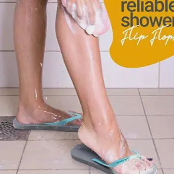 Flip-flops resting on the wet tile floor of a communal shower