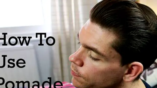 Person applying hair pomade near the hairline where product may transfer to forehead
