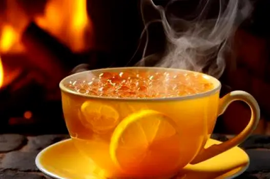 A steaming hot lemon drink in a mug, prepared from a sachet