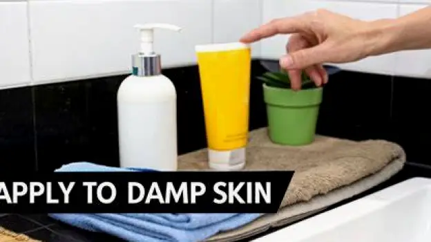 Hands applying thick moisturizer to slightly damp forearm skin