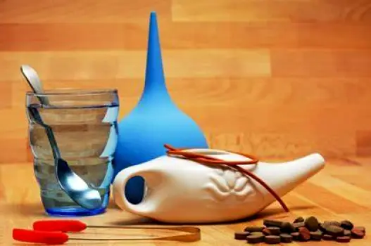 Person pouring distilled water from a container into a neti pot