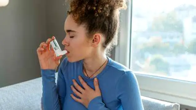 Person using a metered-dose inhaler to take bronchodilator medication