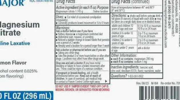 Person reading the label on a bottle of magnesium citrate solution