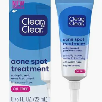 Person applying topical acne cream to the face