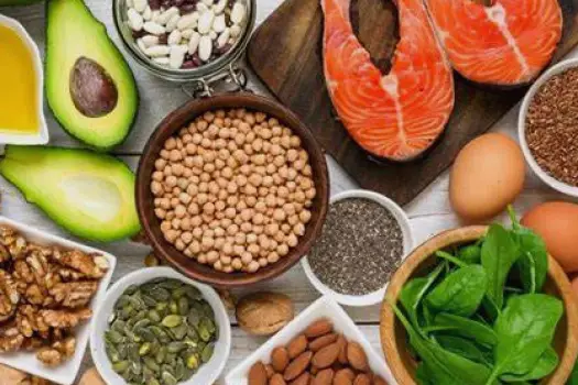 Almonds, sunflower seeds, walnuts, flaxseeds, chia seeds, a small bowl of vegetable oil, and a piece of oily fish